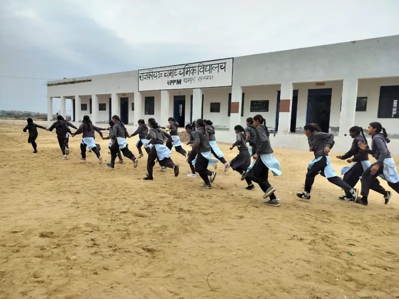 Girls running outside their village school